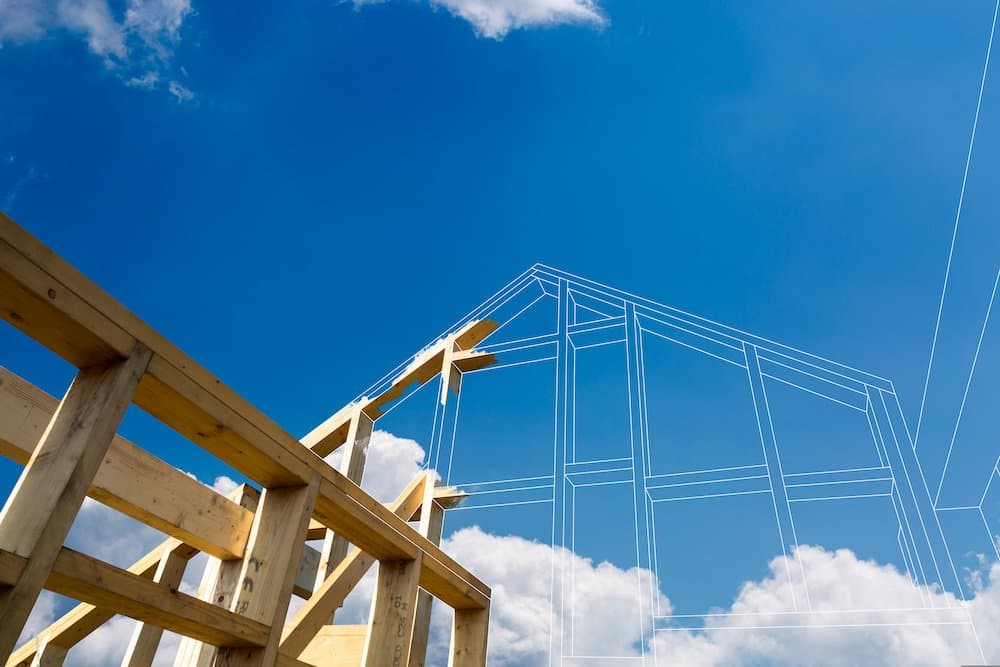 A view of the wooden beams of a home being built, with digital lines continuing the rest of the construction to show wha
