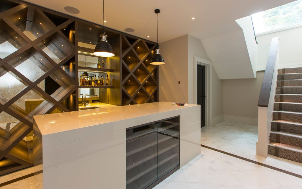 The basement bar at Ridgway Gardens, with triangular wooden wall accents and pendant lighting.